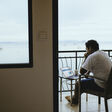 asian young man using laptop in balcony
