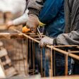 Cropped picture of builders making house foundation at site.
