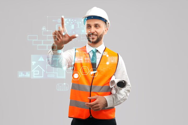 Front view of smiling architect with paper rolls wearing reflective vest and helmet. Digital tactile charts screen, man touching virtual icon on projection. Concept of digitalization, construction.