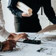 Close up of hands working brainstorming and measuring for cost estimating on paperworks and floor plan drawings about design architectural and engineering for houses and buildings.