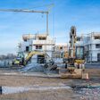 Baustelle auf Neubaugebiet mit Baukran und Baumaschinen