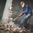 demolition work. Worker builder with sledgehammer destroying interior wall. Rearrangement during renovation. slow motion