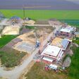 neubausiedlung, baugebiet, stadtentwicklung, baustelle, flächenversiegelung, wohnraummagel, bebauungsplan, neubau, flächenverbrauch, bauindustrie, bauunternehmen, baugewerbe, rohbau, architektur, haus, landschaft, stadt, bauwerk, europa, stadtplanung, plan, planung, bauen, erschlossen, erschließung, straße, mauer, fundament, grundstück, wohnraum, dorfentwicklung, wohnraumnot, politik, umwelt, kanal, erde, sand, baustraße, bebauung, kran, baukran, vogelperspektive, luftbild, container, beton, stein