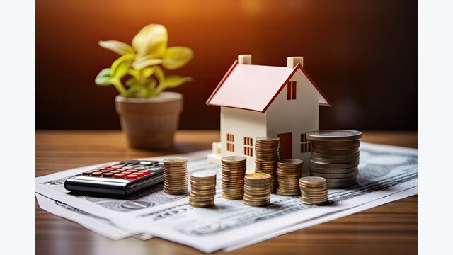 The idea of a home loan, represented by a paper application form, along with a money coin and a model of a house, placed on a table. This represents the financial aspect of loans for real estate