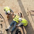 First aid worker accident in construction site, Builder accident fall scaffolding to concrete floor, Safety team help employee arm and leg injury from accident. Top view.