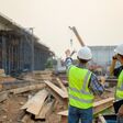 Architect with highway engineering working Discuss and plan a construction project Two engineers supervise the work at the construction site.