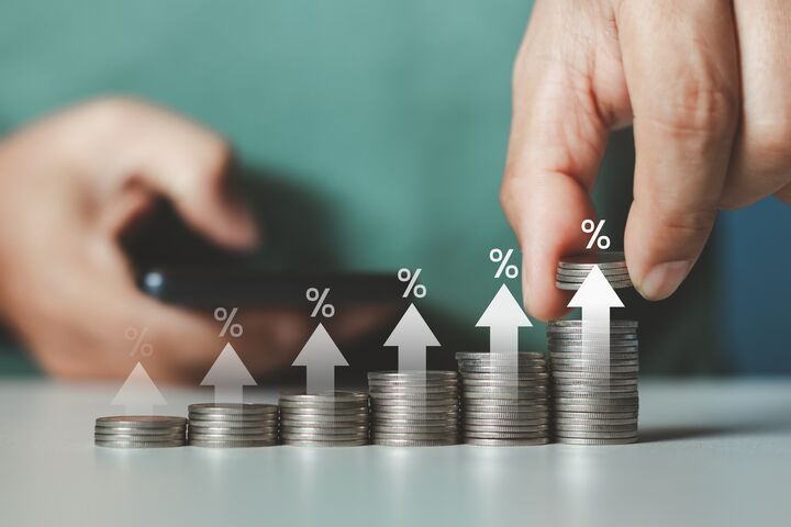 Interest rate and dividend concept. Businessman stacking coins money with up arrow and percentage symbol for financial banking increase interest rate or mortgage investment dividend business growth.