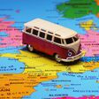 Small toy retro bus in the middle of Europe map. Travel by car concept.