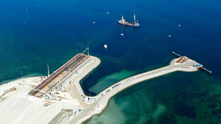 Blick auf die Baustelle der neuen Storstrøm-Brücke: Auf der künstlichen Arbeitsfläche am Meer entstehen die großen Brückenelemente, während Doka die Schalungs- und Traggerüstlösungen für die Produktion liefert.