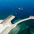 Blick auf die Baustelle der neuen Storstrøm-Brücke: Auf der künstlichen Arbeitsfläche am Meer entstehen die großen Brückenelemente, während Doka die Schalungs- und Traggerüstlösungen für die Produktion liefert.