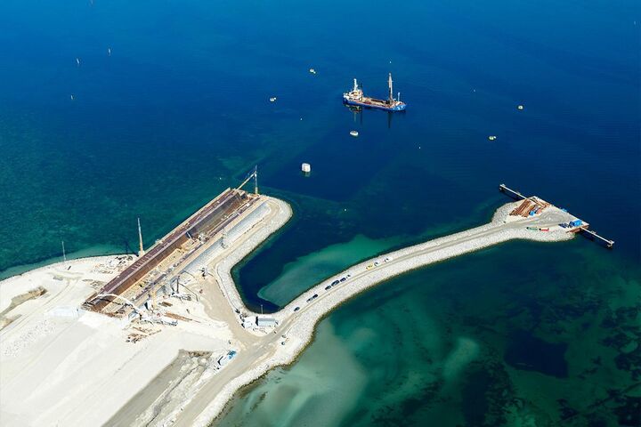 Blick auf die Baustelle der neuen Storstrøm-Brücke: Auf der künstlichen Arbeitsfläche am Meer entstehen die großen Brückenelemente, während Doka die Schalungs- und Traggerüstlösungen für die Produktion liefert.