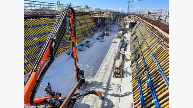 Im Inneren des Bauteils kommen großflächige Schalungssysteme zum Einsatz. Die Aufnahme zeigt den Ausbau einer langen, wannenförmigen Struktur mit geneigten Seitenwänden und engem Arbeitsraum.