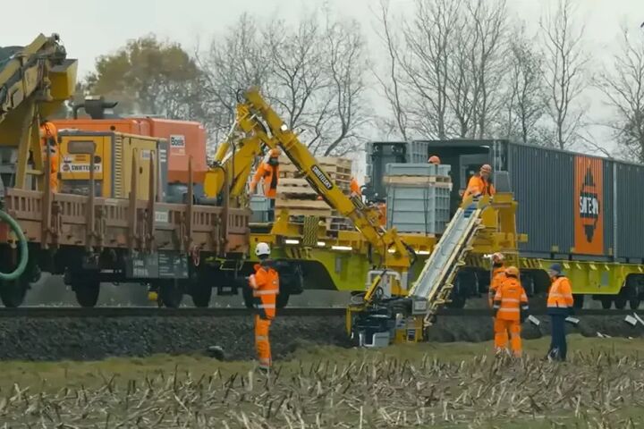 Der komplette Maschinenzug bündelt Materialtransport, Zuführung und Verlegung auf dem Gleis. Personal begleitet den Prozess, kontrolliert die Einbaulage und greift an Sonderstellen ein.
