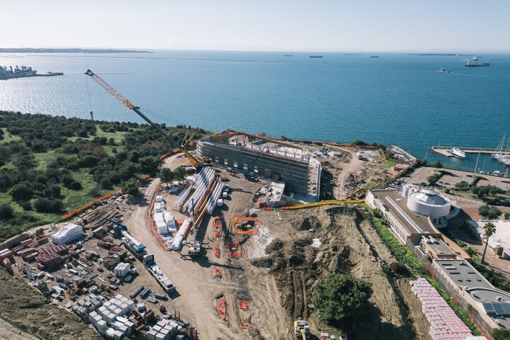 Direkt an der Küste von Taranto entsteht das neue Schwimmstadion für die Mittelmeerspiele 2026. Das Hallendach wird von 26 gebogenen Brettschichtholzbindern getragen, die bis zu 51,8 Meter lang sind.