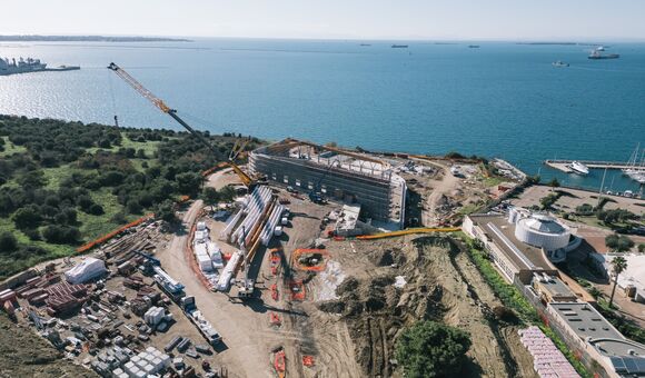 Direkt an der Küste von Taranto entsteht das neue Schwimmstadion für die Mittelmeerspiele 2026. Das Hallendach wird von 26 gebogenen Brettschichtholzbindern getragen, die bis zu 51,8 Meter lang sind.