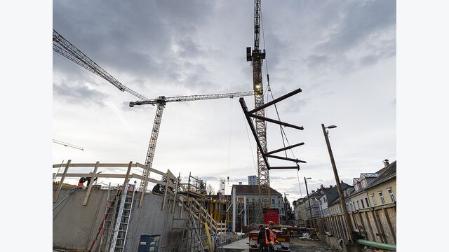 Insgesamt 64 große Stahlelemente wurden für das Tragwerk angeliefert. Einzelne Bauteile wogen bis zu acht Tonnen und mussten mit dem Kran präzise auf dem Rohbau positioniert werden.