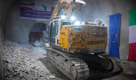 Ein Meißelbagger entfernte die letzte Felsbarriere an der Staatsgrenze. Der mehr als fünf Kilometer lange Anmarsch durch das Gebirge war zuvor im Sprengvortrieb erfolgt.