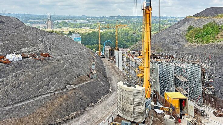 Zwischen den Flanken der ehemaligen Bergbauhalde entsteht der neue Lift- und Notfalltunnel des Alpincenters. Das Baufeld erreicht ein Gefälle von bis zu 23,4 Prozent.