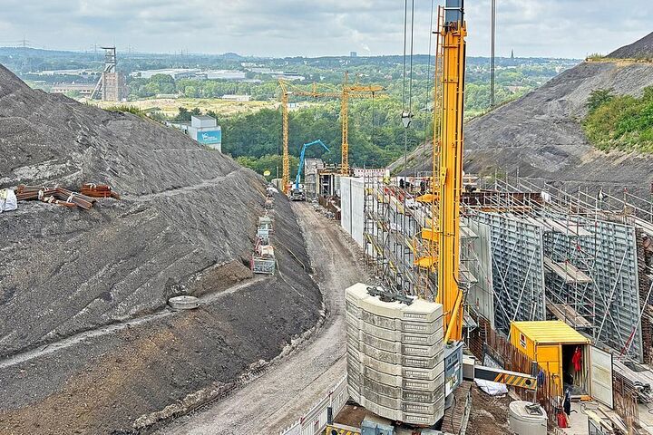 Zwischen den Flanken der ehemaligen Bergbauhalde entsteht der neue Lift- und Notfalltunnel des Alpincenters. Das Baufeld erreicht ein Gefälle von bis zu 23,4 Prozent.