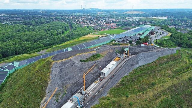 Die Luftaufnahme zeigt die Baustelle entlang der 640 Meter langen Skihalle. Der unterirdische Förderweg bringt die Wintersportler künftig wieder vom Talbereich zur Piste.
