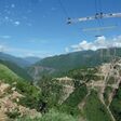 Ein Traversen-Gestell schwebt am Kabelkran über der Chenab-Schlucht: Zwei parallele Systeme mit je 20 Tonnen Tragfähigkeit brachten Stahlteile dorthin, wo kein Bodenkran hinreichte.