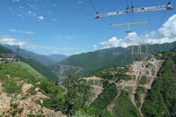Ein Traversen-Gestell schwebt am Kabelkran über der Chenab-Schlucht: Zwei parallele Systeme mit je 20 Tonnen Tragfähigkeit brachten Stahlteile dorthin, wo kein Bodenkran hinreichte.