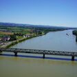 Noch trägt das grüne Stahlfachwerk den Straßenverkehr über die Donau. 2028 soll dieser Überbau innerhalb einer dreimonatigen Totalsperre verschwinden und durch vormontierte neue Tragwerksteile ersetzt werden – eines davon rund 2.500 Tonnen schwer.
