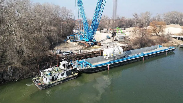 Wo der Wasserweg endete, begann die Schwerlastlogistik an Land: Ein 750-Tonnen-Raupenkran hob einen der Generatoren für den Weitertransport vom Schiff auf die bereitstehende Transporttechnik.