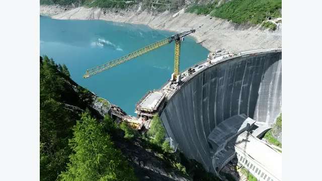 Der eigens für die Baustelle eingesetzte Sonderkran bewegt sich auf Schienen entlang der gekrümmten Mauerkrone. Das 219 Tonnen schwere Gerät besitzt einen 65 Meter langen Ausleger.
