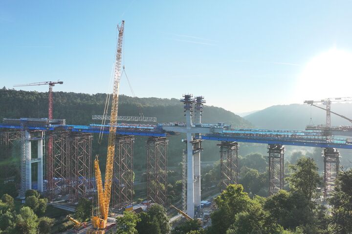 Hoch über dem Neckartal wächst die Hochbrücke Horb zusammen. Für die Montage der schweren Stahlbauteile kam unter anderem ein 700-Tonnen-Raupenkran zum Einsatz; die Fahrbahn liegt später rund 70 Meter über dem Tal.