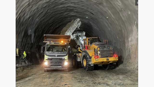 Ein Radlader übernimmt das beim Vortrieb gelöste Material und belädt einen Lkw für den Abtransport aus dem Tunnel – Teil der laufenden Logistik unter Tage.