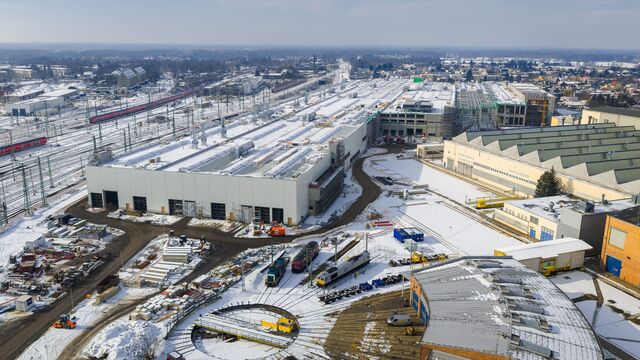 Gebaut wird mitten im bestehenden Bahnareal: Die Luftaufnahme zeigt die neue Werkhalle zwischen Gleisanlagen, Bestandsgebäuden und laufender Bahninfrastruktur.