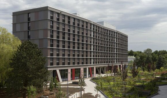 Eines der beiden siebengeschoßigen Wohngebäude des neuen Hochschulcampus in Rostock. Die Wohnriegel wurden überwiegend aus vorgefertigten Holzmodulen errichtet.