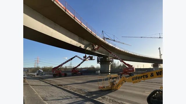 Arbeiten an der Unterseite des Brückenüberbaus: Auf Hubarbeitsbühnen führen Beschäftigte Montagearbeiten an der Hochstraße Elbmarsch durch. Die Erweiterung erfolgte bei weitgehend aufrechterhaltenem Verkehr.