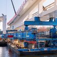 Eine rund 1.500 Tonnen schwere Stahlbrücke wird am Berliner Bundeskanzleramt über die Spree verschoben. Für die aufwendige Montage setzte die österreichische Felbermayr-Gruppe unter anderem schwimmende Pontons und spezielle Schwerlasttechnik ein.
