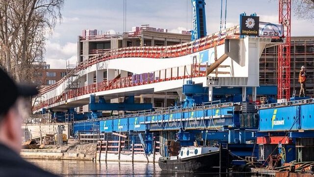 Stück für Stück wurde die vormontierte Stahlbrücke über die Spree bewegt. Blaue Schwerlastkonstruktionen trugen das Bauwerk während des Verschubs, an dem mehrere Unternehmen unter der Gesamtverantwortung von Implenia beteiligt waren.